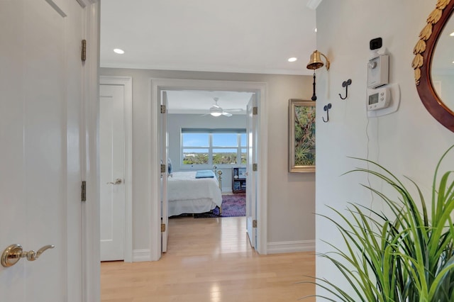 hall with ornamental molding, recessed lighting, light wood-style flooring, and baseboards