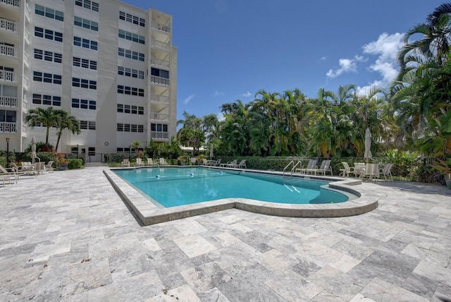 pool with a patio and fence