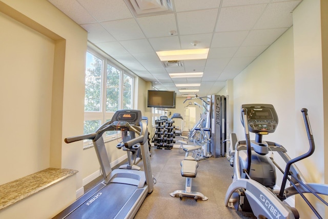 workout area featuring baseboards, visible vents, and a drop ceiling