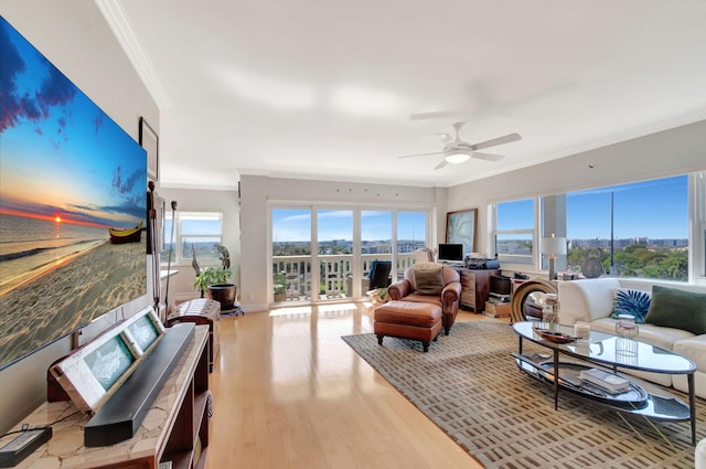 living room with a ceiling fan, ornamental molding, and wood finished floors