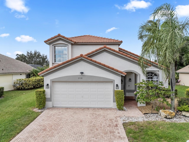 mediterranean / spanish-style home featuring decorative driveway, stucco siding, a garage, a tiled roof, and a front lawn