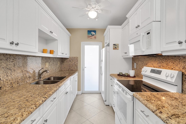 kitchen with a sink, white appliances, light tile patterned floors, and white cabinetry