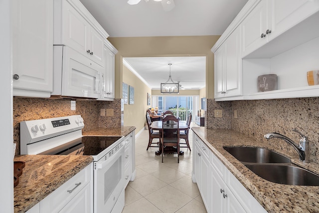 kitchen with white appliances, light tile patterned floors, a sink, white cabinetry, and a chandelier