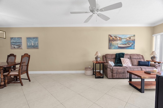 living area with light tile patterned floors, baseboards, a ceiling fan, and crown molding
