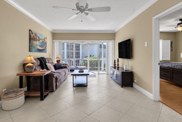living area with light tile patterned floors, baseboards, ceiling fan, and ornamental molding