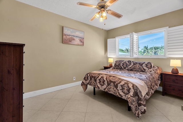 bedroom with light tile patterned floors, baseboards, a textured ceiling, and a ceiling fan
