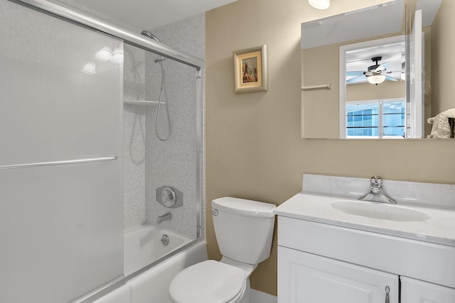 bathroom featuring combined bath / shower with glass door, toilet, vanity, and a ceiling fan