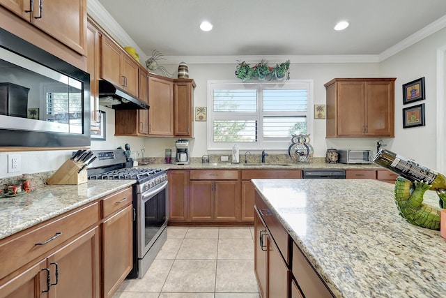 kitchen featuring light stone counters, light tile patterned flooring, under cabinet range hood, ornamental molding, and appliances with stainless steel finishes