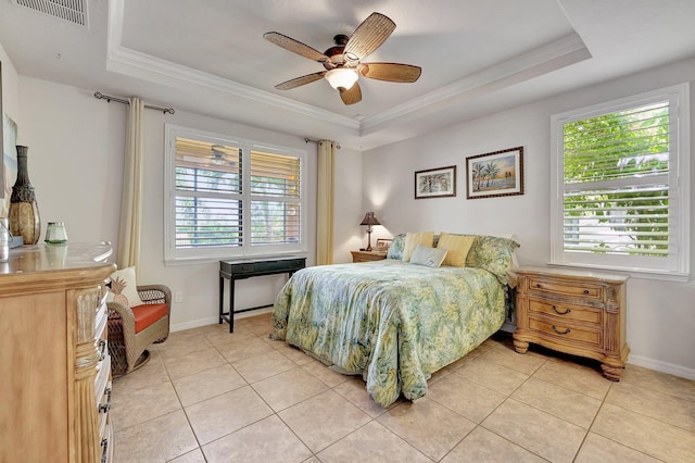 bedroom featuring light tile patterned floors, visible vents, baseboards, ornamental molding, and a tray ceiling