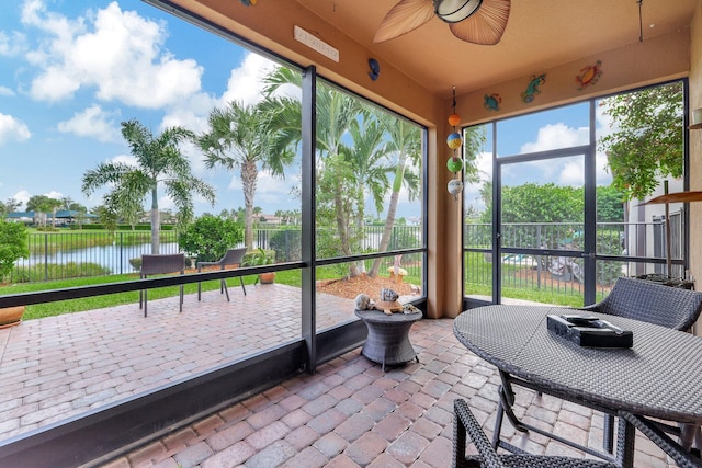 sunroom / solarium featuring a water view