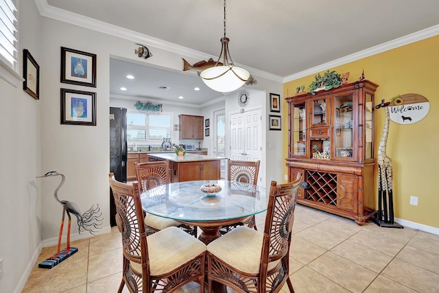 dining area with light tile patterned floors, baseboards, and ornamental molding