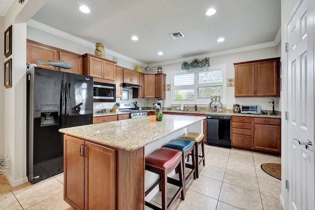 kitchen with black appliances, a kitchen island, visible vents, and crown molding