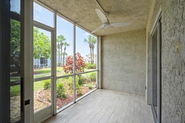 unfurnished sunroom with a ceiling fan