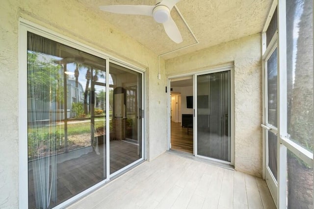 unfurnished sunroom featuring a ceiling fan