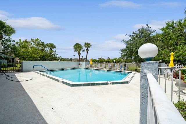 pool featuring fence and a patio