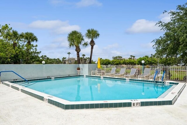 view of swimming pool featuring fence