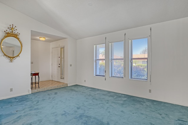 unfurnished room featuring baseboards, lofted ceiling, and carpet floors