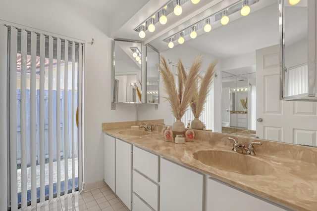 full bathroom with tile patterned flooring, double vanity, a stall shower, and a sink