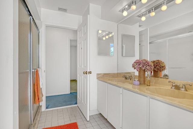 bathroom with a shower stall, double vanity, visible vents, and a sink