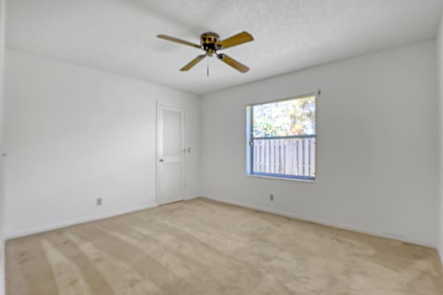 spare room with light carpet and ceiling fan