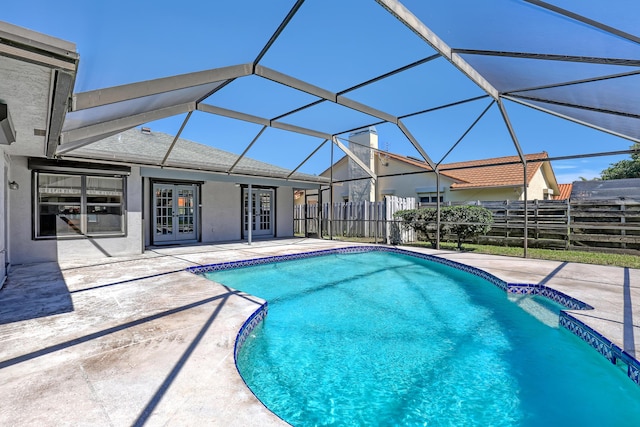 view of swimming pool featuring a patio, fence, french doors, glass enclosure, and a fenced in pool