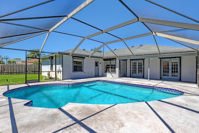 view of pool with a fenced in pool, fence, glass enclosure, french doors, and a patio