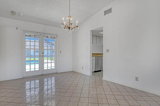 unfurnished room with visible vents, a textured ceiling, french doors, light tile patterned floors, and vaulted ceiling