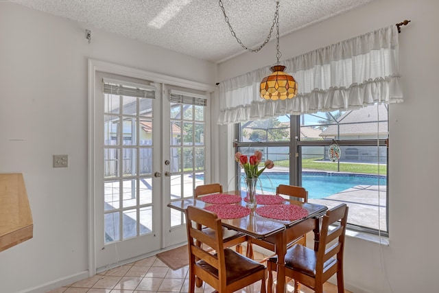 dining room with light tile patterned flooring, french doors, and a textured ceiling