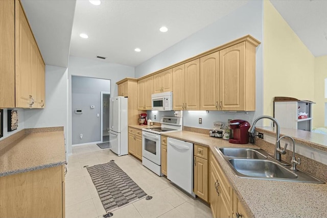 kitchen with recessed lighting, white appliances, light brown cabinets, and a sink