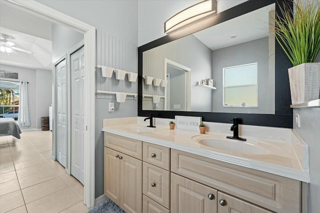 full bathroom with double vanity, a ceiling fan, a sink, and tile patterned floors