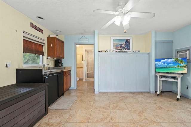 kitchen featuring a textured ceiling, light tile patterned flooring, a sink, a ceiling fan, and light countertops