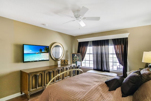 bedroom with a ceiling fan, baseboards, and wood finished floors