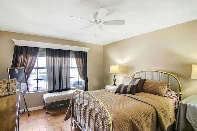 bedroom with wood-type flooring, baseboards, and a ceiling fan