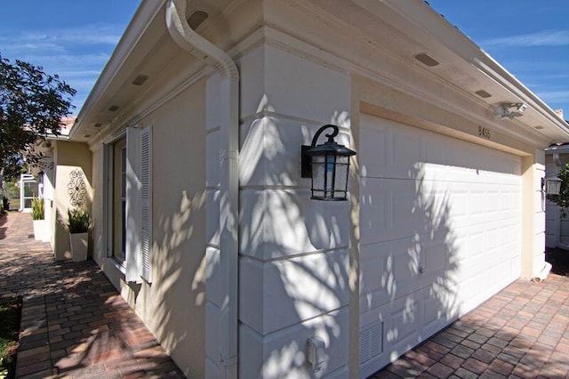 view of side of property with a garage and stucco siding