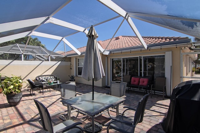 view of patio / terrace with outdoor dining space, a lanai, grilling area, and an outdoor hangout area