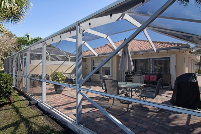 exterior space with a lanai, a patio area, a tile roof, and outdoor dining space