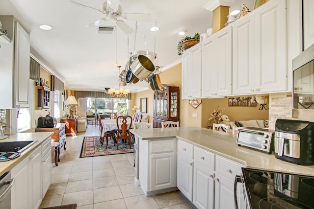 kitchen with light countertops, open floor plan, visible vents, and a sink