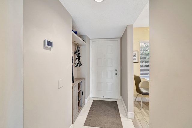 interior space with baseboards and light tile patterned flooring