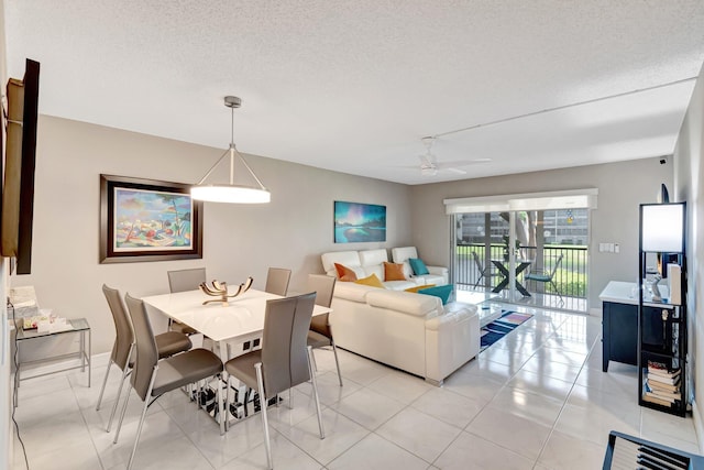 dining room with light tile patterned flooring, ceiling fan, and a textured ceiling