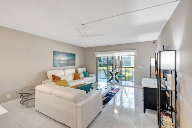 living room featuring light tile patterned floors, baseboards, and a ceiling fan