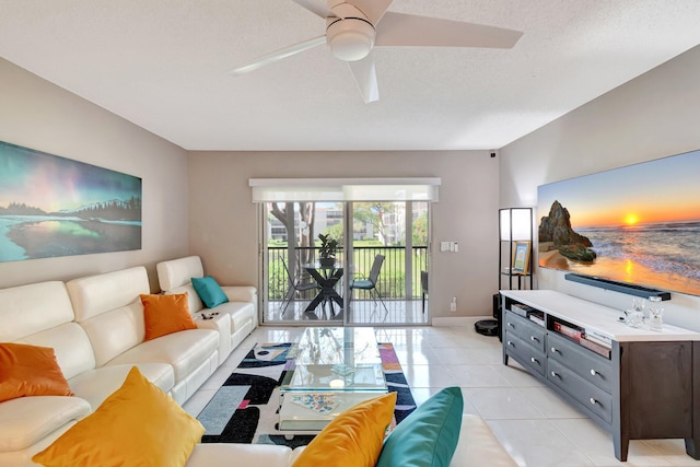 living room with light tile patterned floors, ceiling fan, a textured ceiling, and baseboards