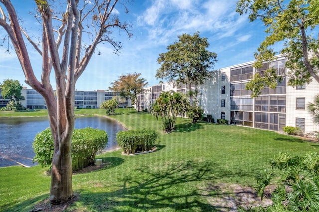 view of community with a lawn and a water view