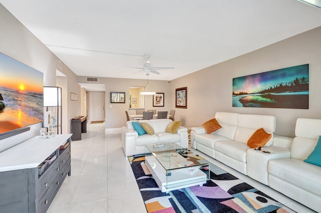 living area featuring light tile patterned floors, visible vents, and a ceiling fan