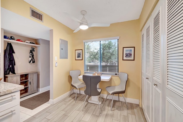 dining area featuring baseboards, wood tiled floor, visible vents, and electric panel