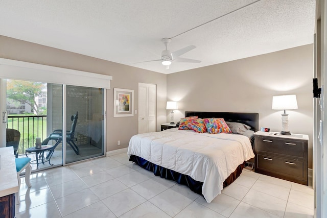 bedroom featuring light tile patterned floors, a textured ceiling, baseboards, and access to exterior