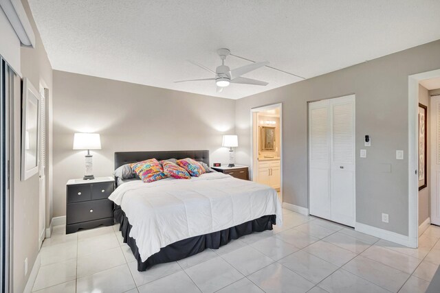 bedroom with light tile patterned flooring, ensuite bath, a ceiling fan, and baseboards