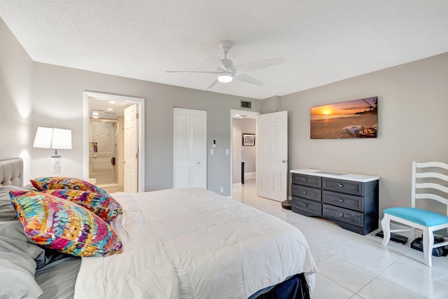 bedroom with light tile patterned floors, visible vents, ceiling fan, ensuite bathroom, and a closet