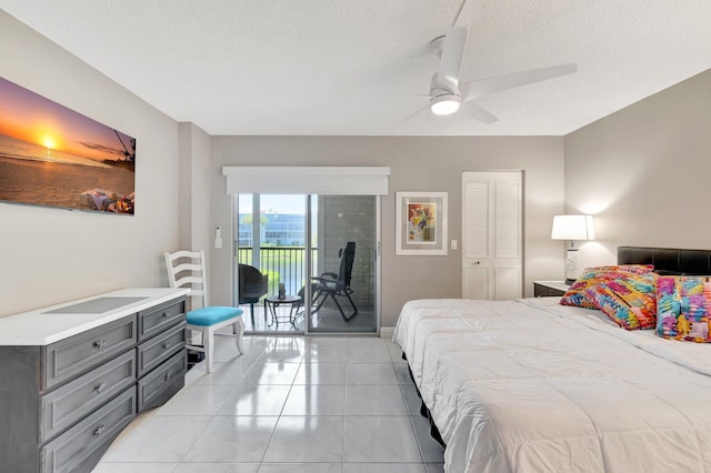 bedroom with a textured ceiling, access to outside, light tile patterned floors, and ceiling fan