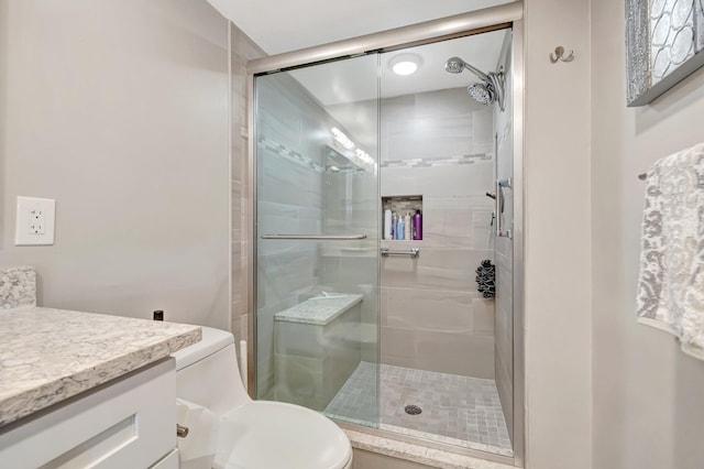 bathroom featuring a stall shower, vanity, and toilet