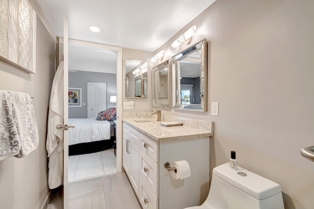 ensuite bathroom featuring vanity, tile patterned flooring, connected bathroom, and toilet